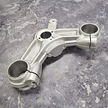 A close up photo showing a vapour blasted engine part. The clean part sits on a marble surface.