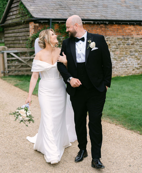 Bride and groom walking together smiling during outdoor wedding at Dodford Grange