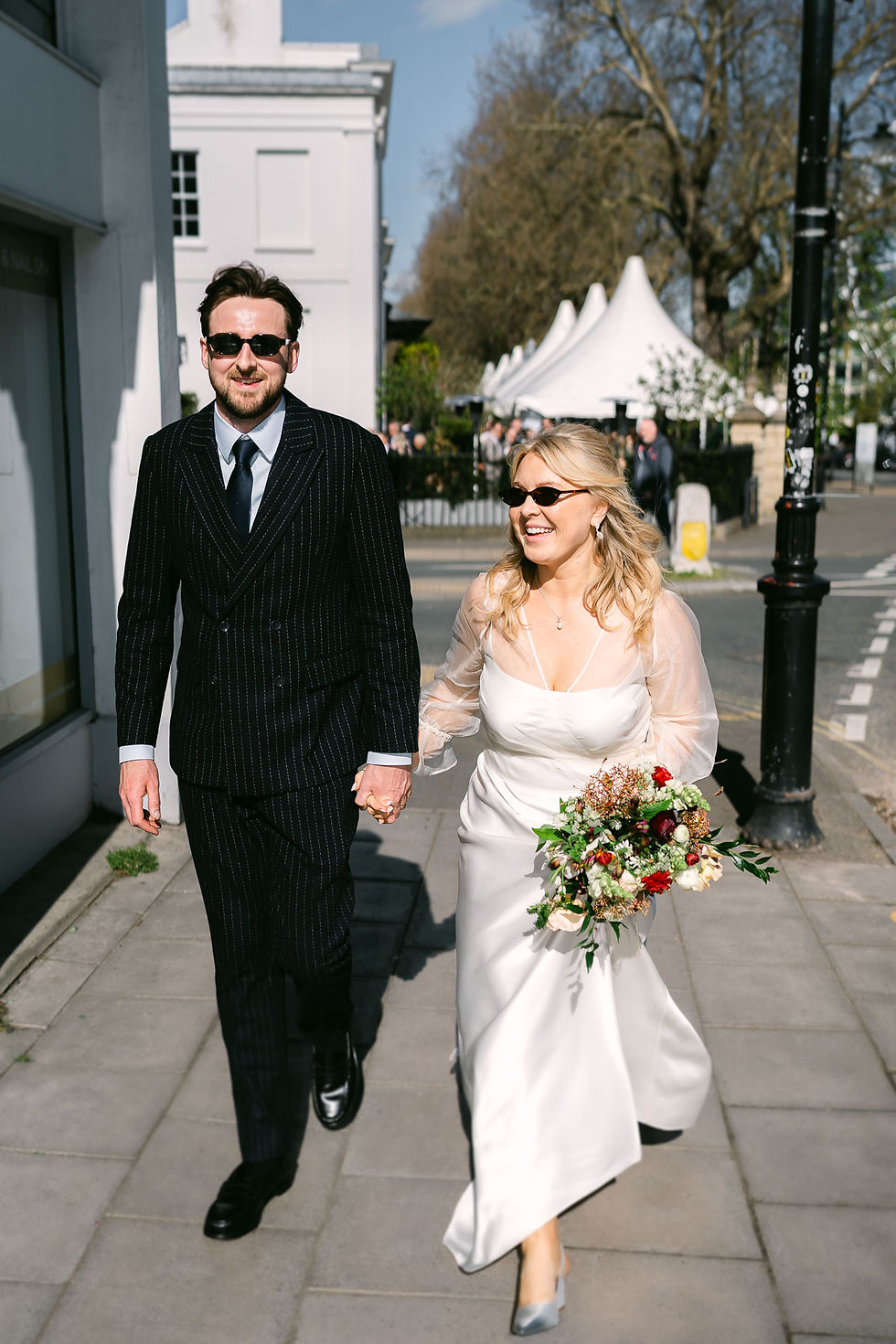 Bride and groom walking together in Cheltenham during No.131 wedding, natural documentary wedding photography