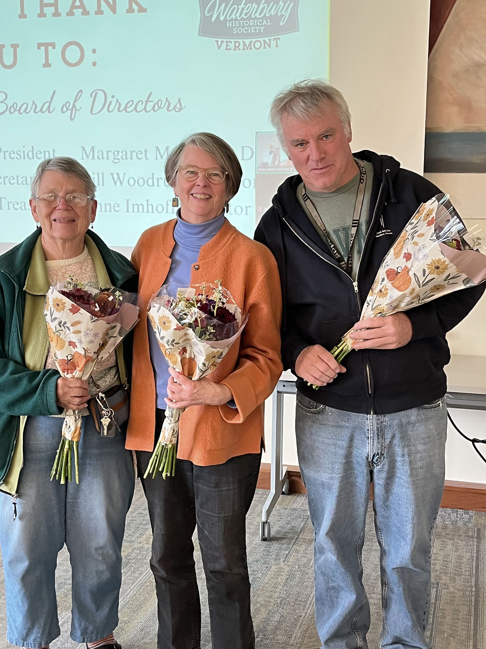 Two women and one man smiling and holding bouquets of flowers