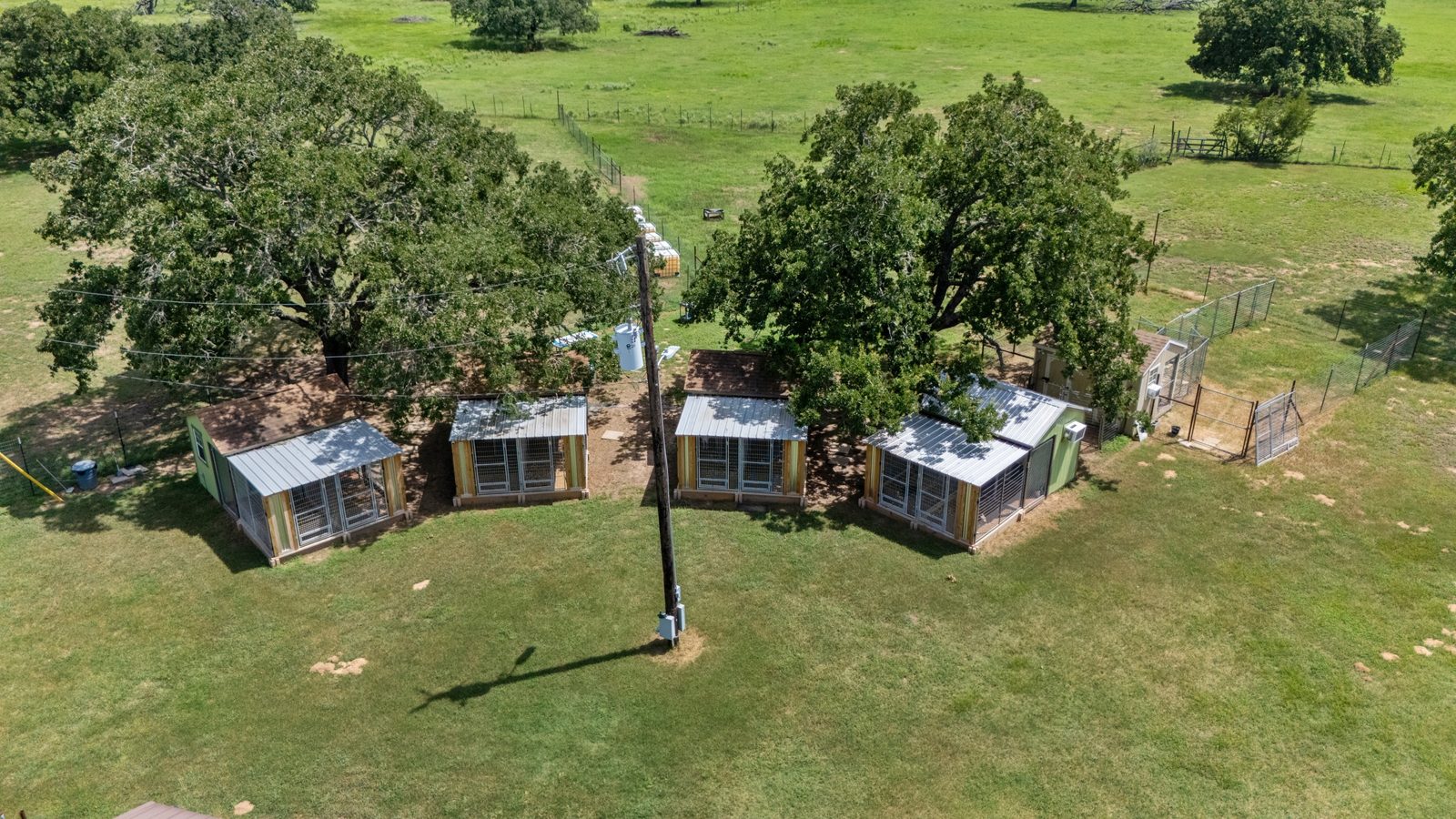 Aerial view of the bungalows and fenced play yards surrounded by pasture