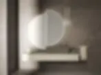 Mobile bagno sospeso chiaro con lavabo centrale e grande specchio circolare retroilluminato diviso in due elementi.