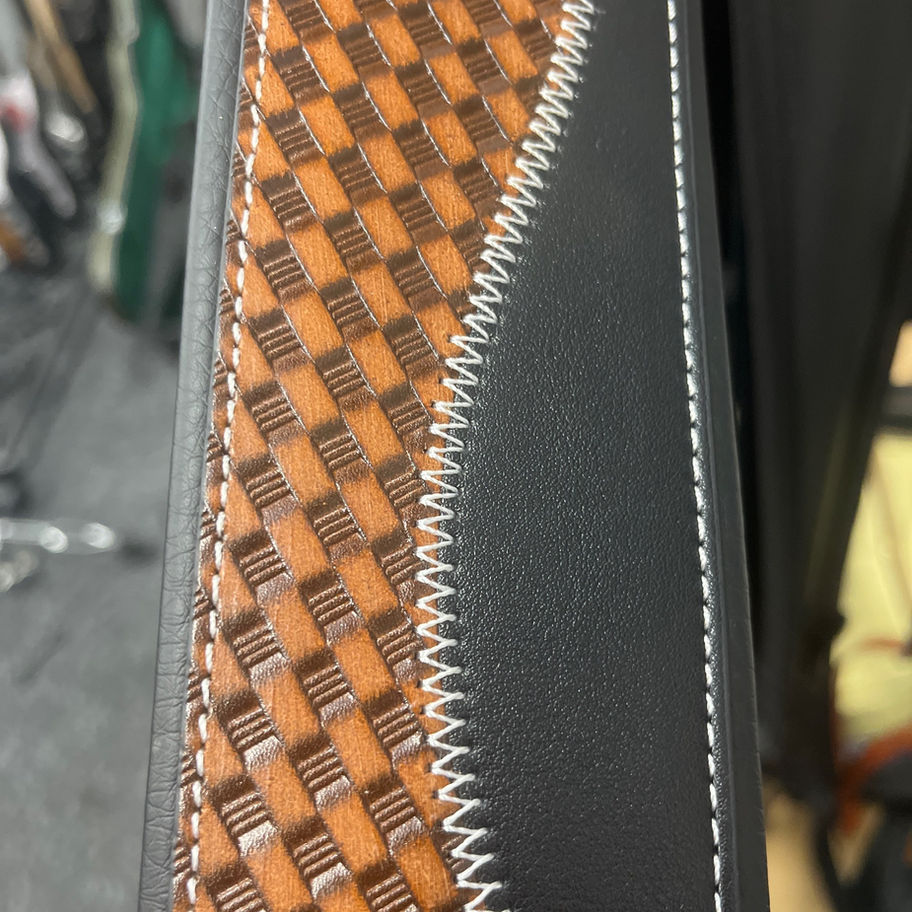Brown and black leather design with white stitching and woven pattern detail.