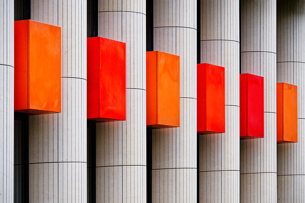 Colonnes blanches verticales avec boîtes rouges proéminentes en motif répétitif. Design moderne et contrasté. Aucune action ou texte.