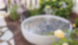 DIY water fountain made with ceramic pots, pebbles, and a small submersible pump.