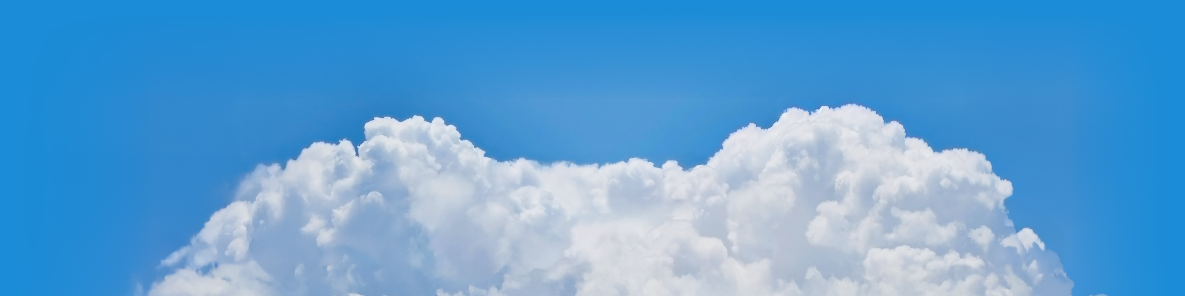 Peaceful blue sky with soft white clouds, framing a sun and kites above the horizon.