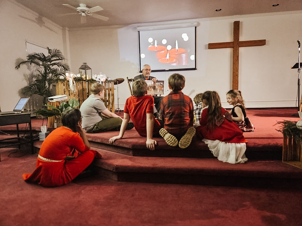Children listening to a story on a church stage.
