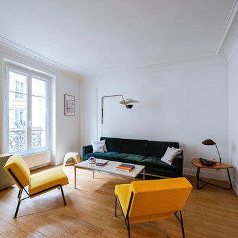 Salon avec mobilier contemporain, fauteuils jaunes et parquet en bois