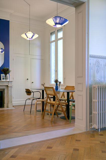 Salle à manger des bureaux Tudigo dans un immeuble haussmannien, parquet point de Hongrie et moulures d'origine — photographe bureaux Paris