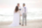 Couple holding hand during beach wedding ceremony