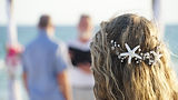 Bride looking at groom and officiant under wdding arch