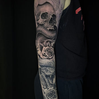 Black and grey skull, snake and rose sleeve tattoo by Titan Tattoo in Nashville.