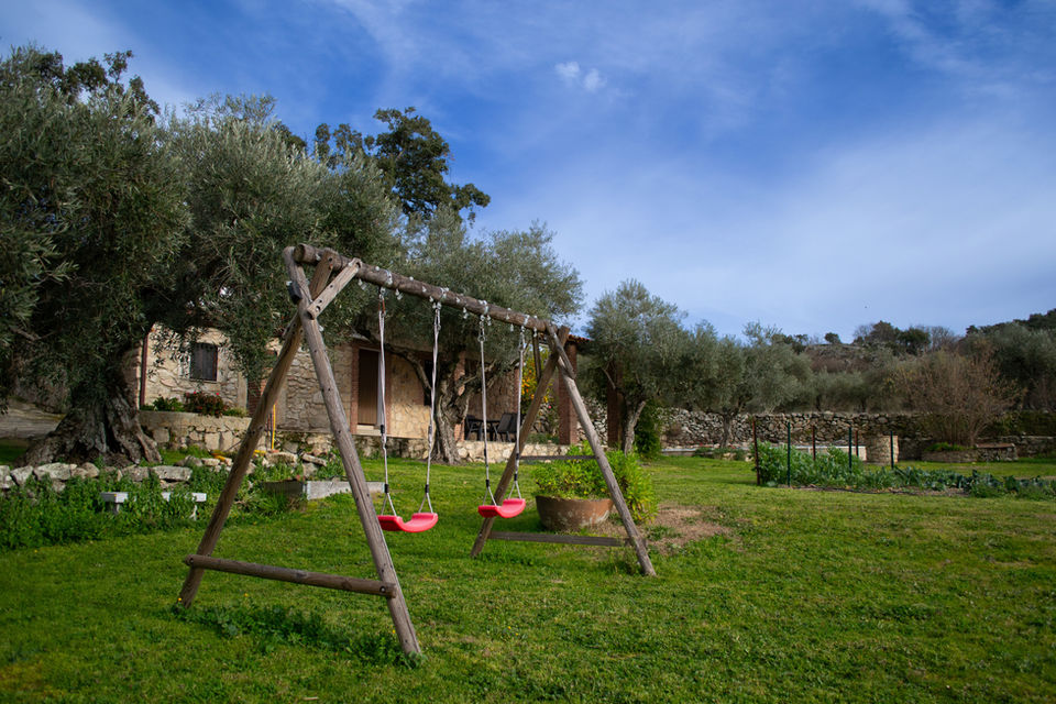 Vista del patio de la casa rural La Recuera con zona de recreo infantil con columpios
