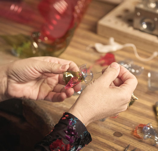 Manos creando joyas con plástico reciclado
