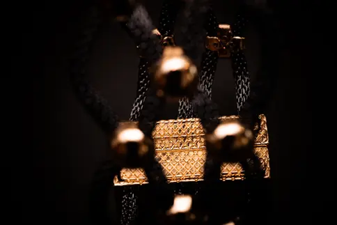 Verzierter Magnetverschluss des Armbands goldfarben – filigrane Gravur durch das geflochtene Netz sichtbar.