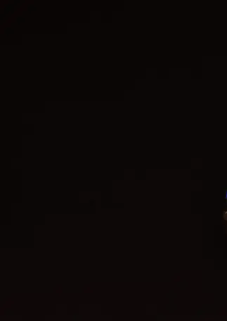 Vergoldete Ohrstecker mit Lapis Lazuli in Frontalansicht, nebeneinander auf schwarzem Hintergrund.