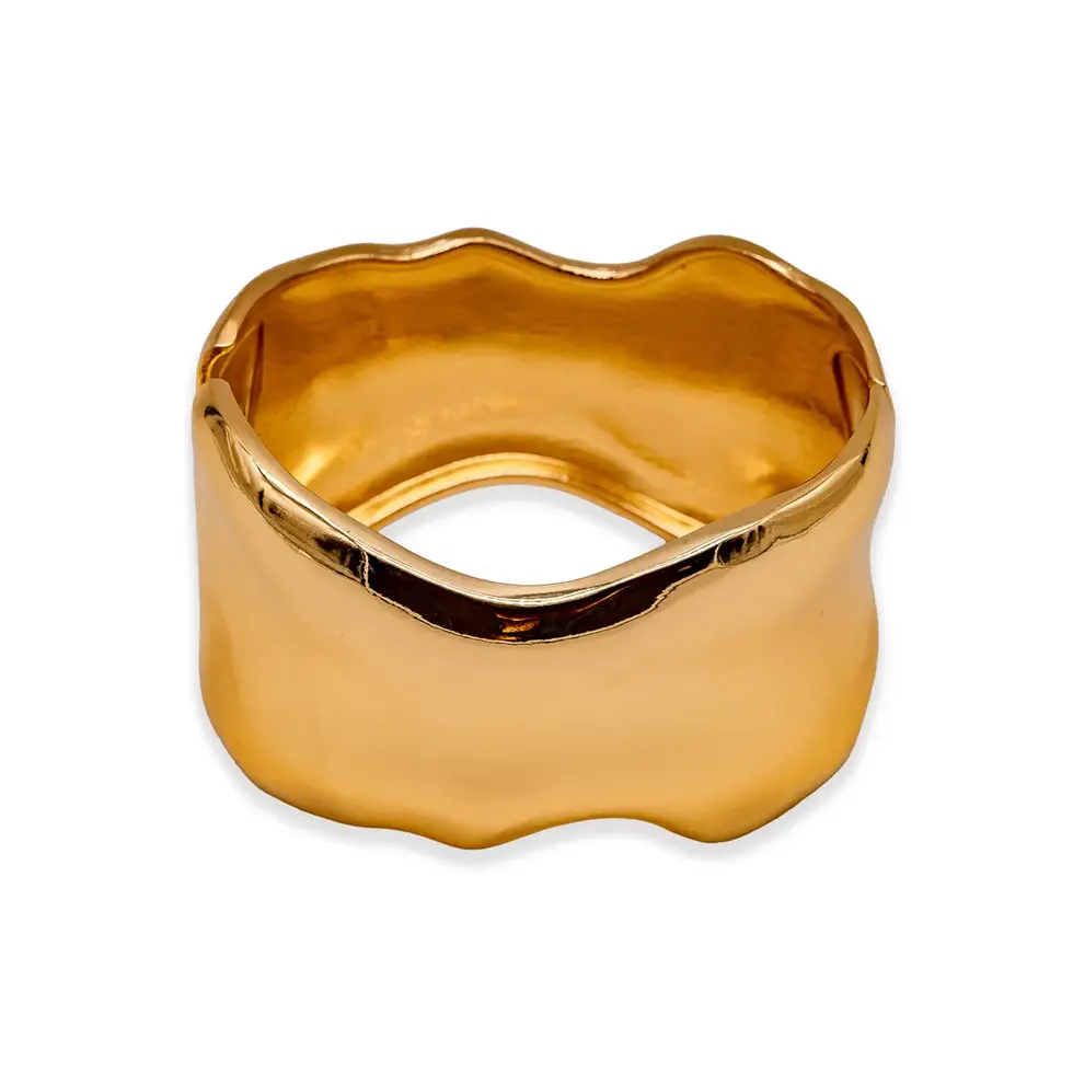 Goldfarbener Armreif mit organischer, fließender Form auf dunklem Hintergrund, eleganter Schmuck mit glatter Oberfläche.