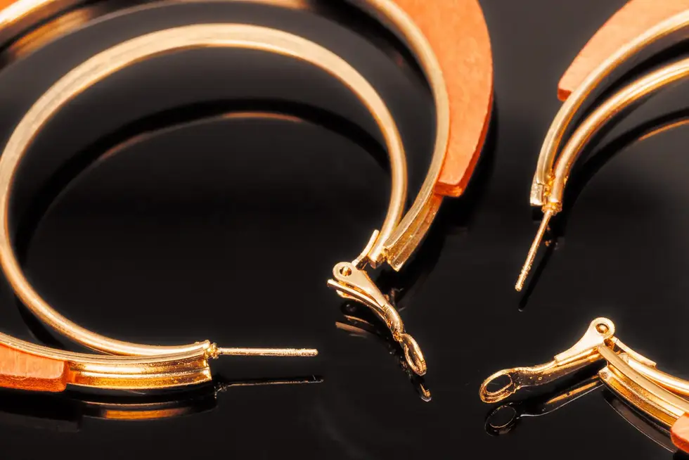 Detailaufnahme des goldfarbenen Verschlusses der Holzcreolen.
