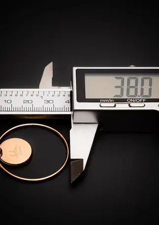 Ohrringe goldfarben mit Naturstein – Messung mit Schieblehre zeigt Durchmesser von 38 mm.