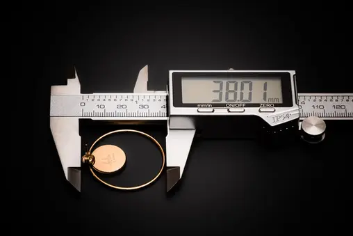 Ohrringe goldfarben mit Naturstein – Messung mit Schieblehre zeigt Durchmesser von 38 mm.