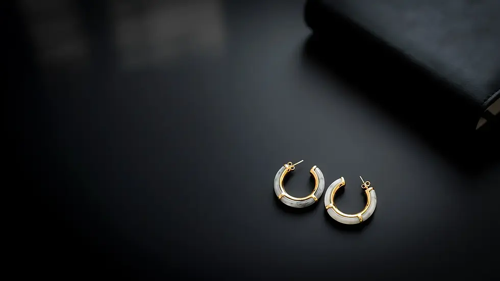 Creolen in goldfarbener Optik mit Acetat auf dunklem Schreibtisch, Büro-Hero-Motiv, kein Echtschmuck. Avirelle.