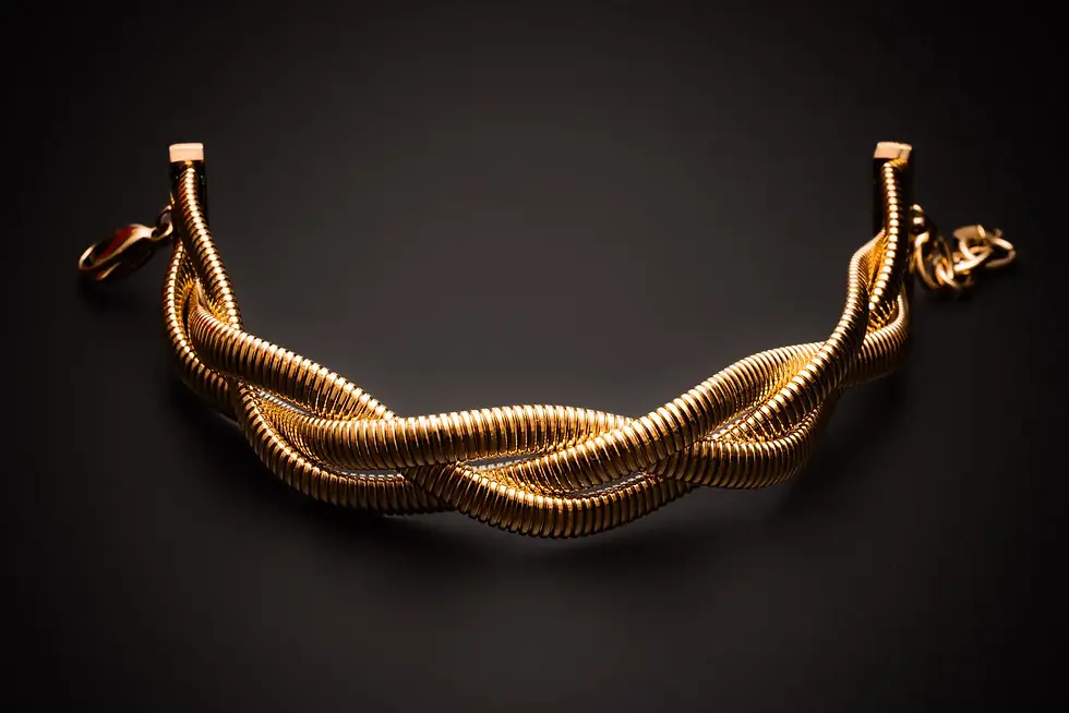 Geflochtenes Armband goldfarben in eleganter Frontansicht auf dunklem Hintergrund.