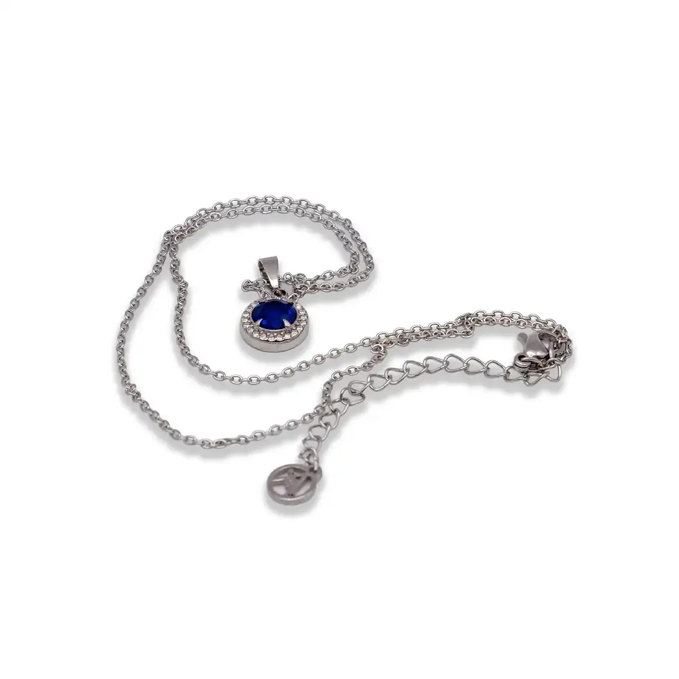 Silberfarbene Halskette mit rundem Anhänger und blauem Zirkon auf hellem Hintergrund, fein und schlicht gestaltet. Avirelle.