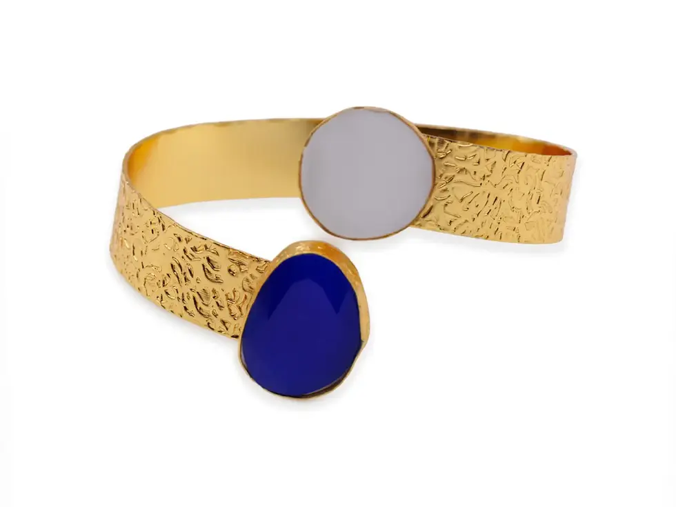 Detailansicht eines offenen Armreifs mit strukturiertem Metall und blauem Cats-Eye-Stein sowie Perlmutt, Avirelle.