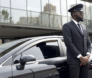 Professional ground transportation driver standing next to the car