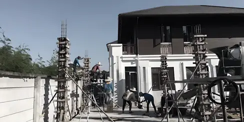 On-site construction at Fah Luang Villas showing structural works, formwork, scaffolding, and partially completed two-storey façades.