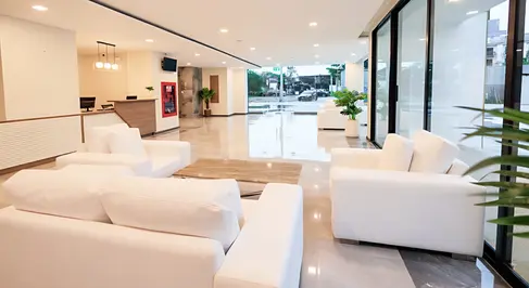 Lobby arrival view at B2 Khon Kaen Premier Hotel showing full-height glazing, reception positioning, and clear circulation paths.