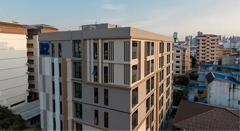 Upper-level view of B2 Huai Khwang Premier Hotel showing modular façade rhythm, corner articulation, and integration within Bangkok’s urban context.