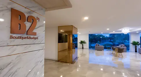 Hotel lobby interior at B2 Rayong featuring reception area, seating, polished flooring, and daylight-filled space.