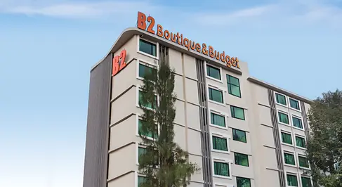 Daytime view of B2 Ubon Premier Hotel façade with integrated signage and vertical screening elements.