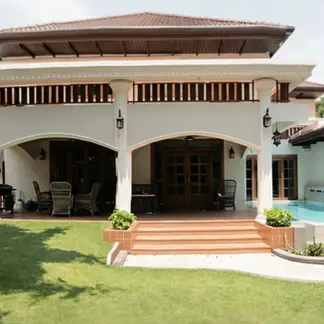 Garden elevation of Nimman House showing arched verandas, raised terrace, courtyard lawn, and classical tropical architectural proportions