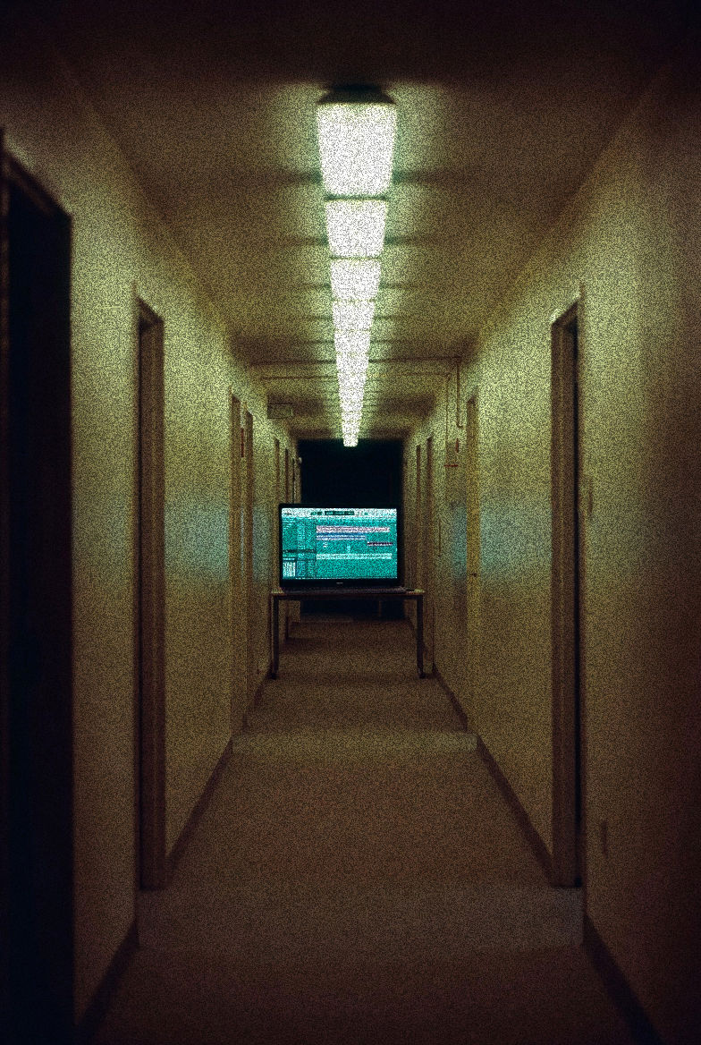 Dim beige hallway with fluorescent lights and a TV showing green static, the visual equivalent of a lo-fi mix