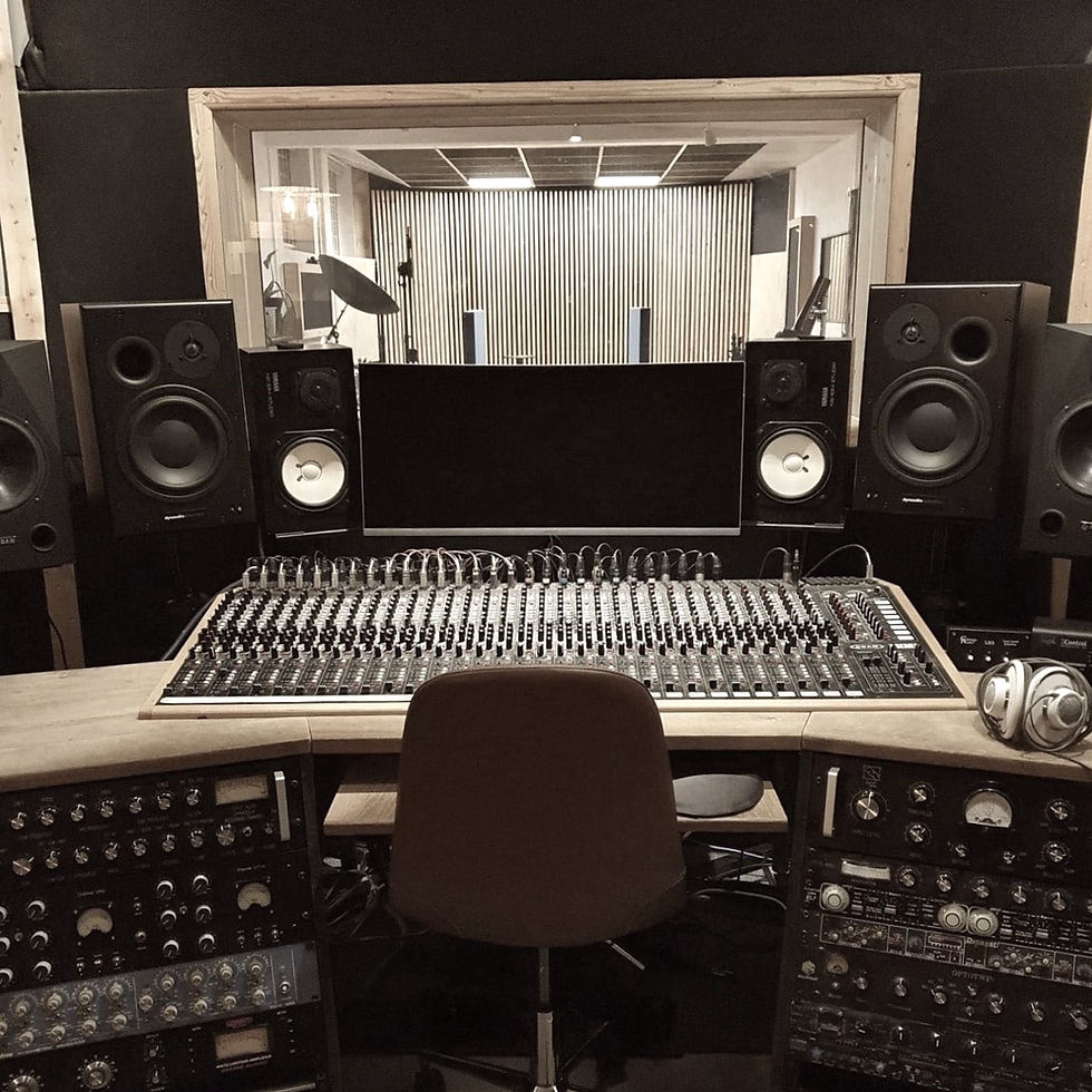Tapetown control room with mixing console, studio monitors and outboard audio equipment.