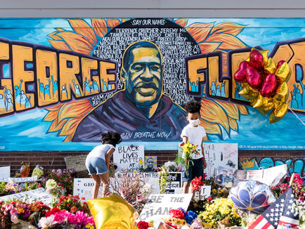 A mural that reads George Floyd with a rendering of him in the middle