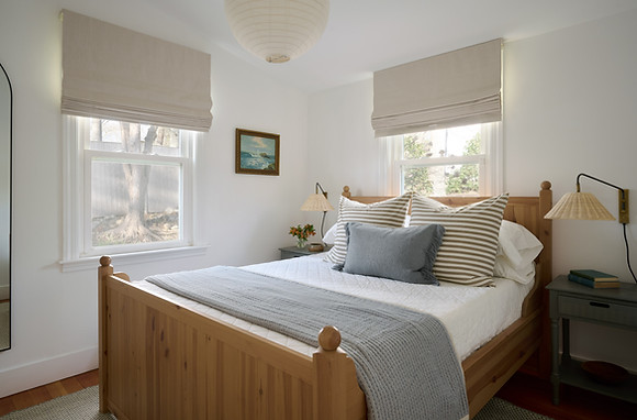 Queen bedroom with crisp white bedding and mini-split AC at Lake Shore Cottage
