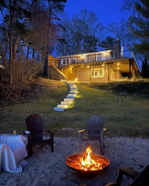 Private sandy beach with kayaks, paddle boards, and fire pit at Lake Shore Cottage