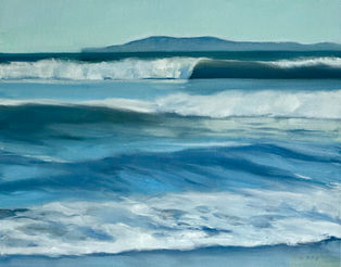 beach with crashing waves and island mountain