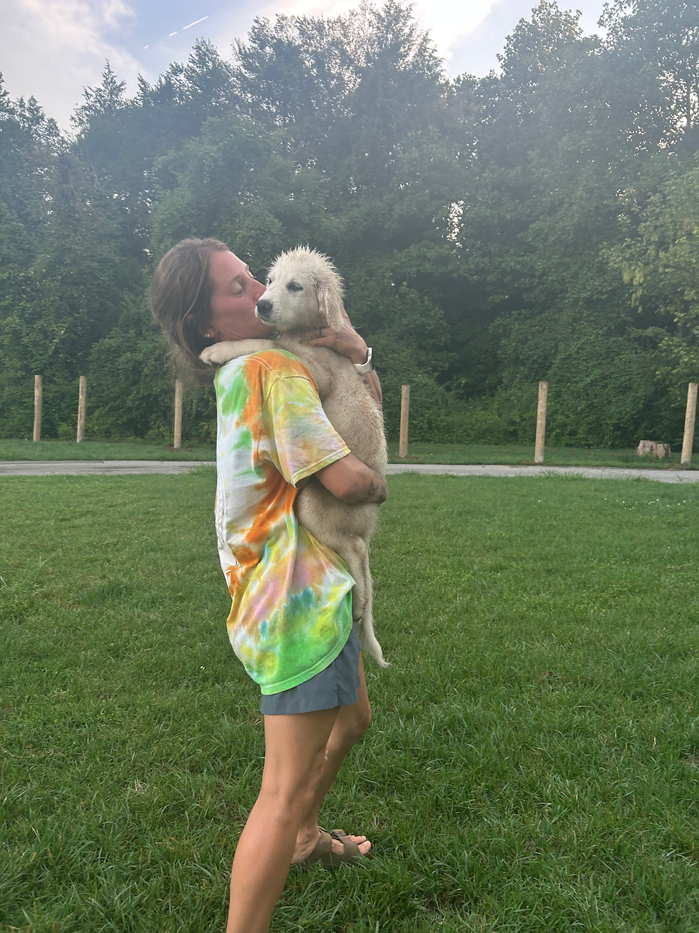 Woman hugging a fluffy white dog at an animal rescue sanctuary