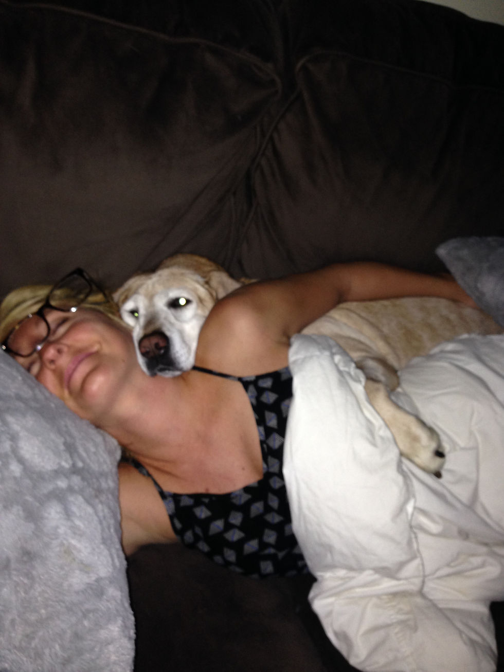 A woman sleeping beside a dog at an animal rescue sanctuary