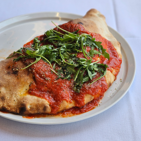 Delicious ham and mushroom calzone, oozing with flavor and covered in savory tomato sauce. Perfectly baked and golden, this Italian specialty promises a mouthwatering combination of tender ham, earthy mushrooms, and tangy tomato goodness. A heavenly treat for pizza lovers seeking a satisfying, indulgent meal.