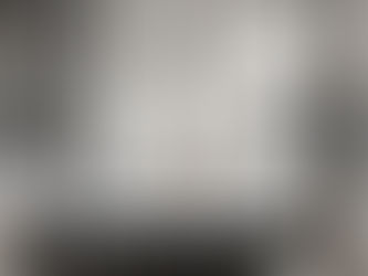 Luxurious bathroom with a black freestanding tub, gold faucet, marble wall, and large windows. Calm ambiance with natural light.