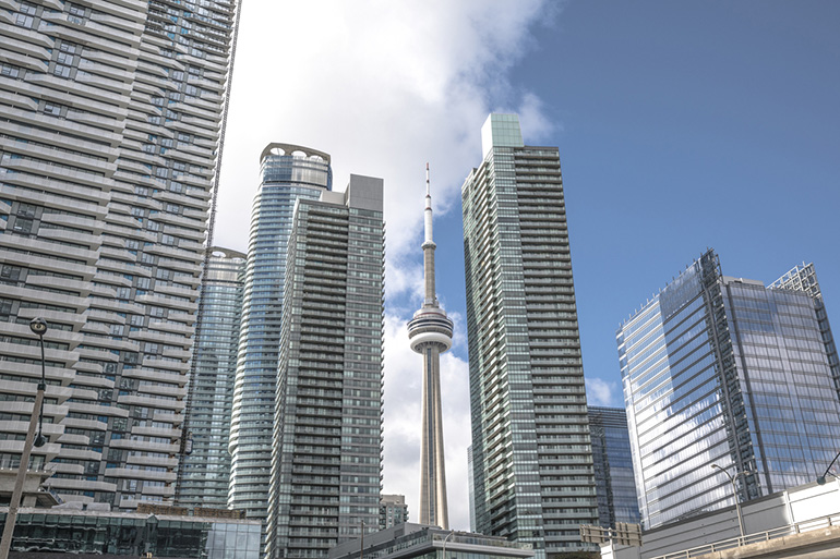 The CN Tower in the middle of numerous glass-clad condominiums overtaking the Toronto skyline