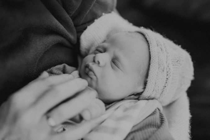Neugeborenes Baby im Arm schläft