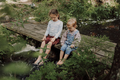 Zwei Kinder spielen am Bach