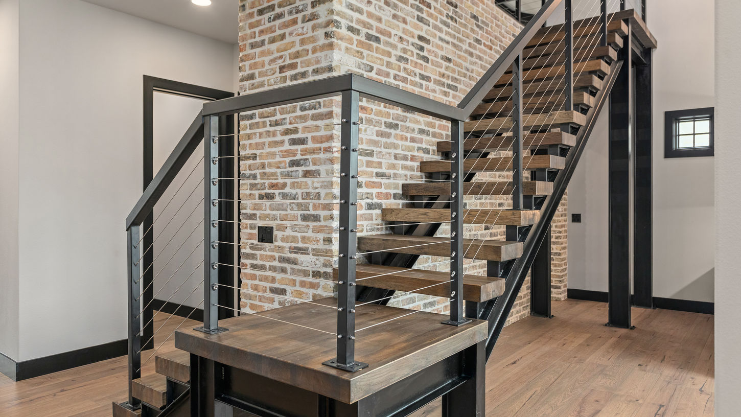 Unique metal stair case that wraps around the colored brick wall