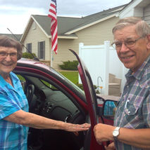 Volunteer opening the car door for client.